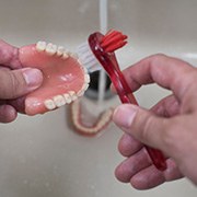 a person cleaning their dentures