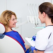 Mature woman talking to dental team member